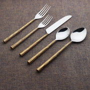 Set of cutlery with wooden handles on a textured brown surface