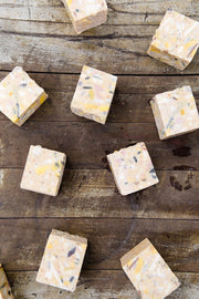 Natural hand and fabric bar soap shown on wooden backdrop
