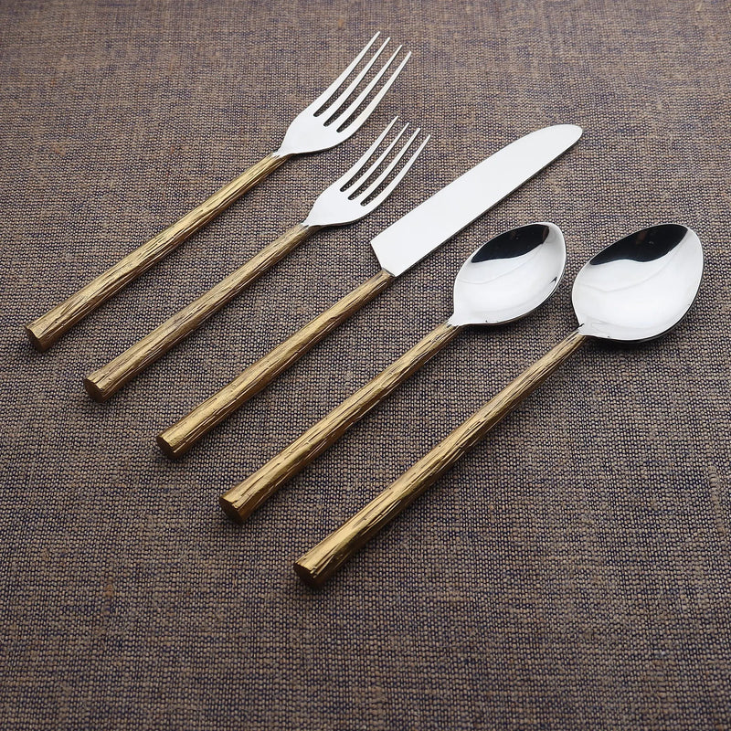 Set of cutlery with wooden handles on a textured brown surface
