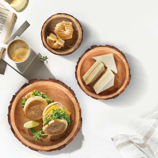 Three wooden bowls with natural raw edge with food on a white surface