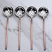 Four ladles slotted spoons with copper handles on a marble background