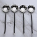 Four silver ladles on a marble surface