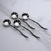 Set of four silver spoons on a marble surface