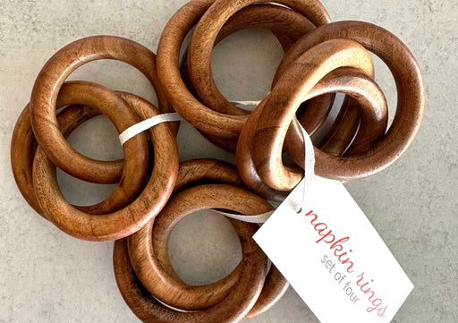 Set of wooden napkin rings with a tag on a neutral background